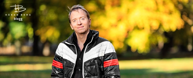 Komikern Håkan Berg i privata kläder ser nöjd ut bland höstlöven